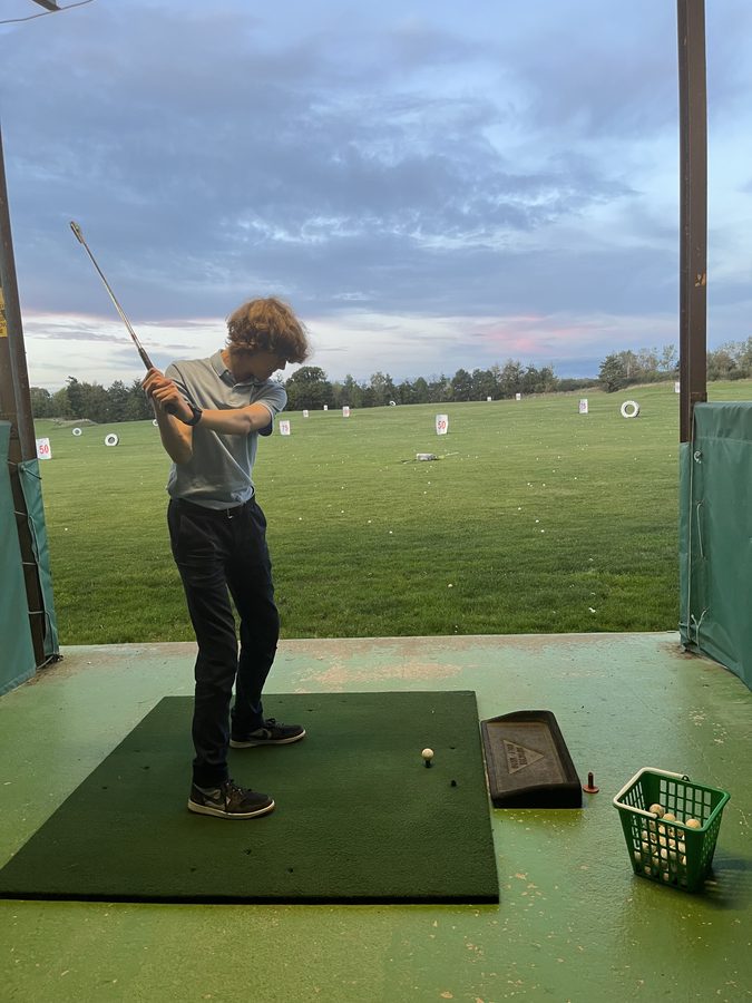Ihor Melashchenko practicing his golf swing at a driving range